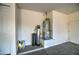 View of water softener and water heater inside the two car garage with painted walls and cement floors at 269 E Horseshoe Dr, Chandler, AZ 85249