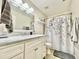 Bright bathroom with a large mirror, a white vanity and a decorative shower curtain at 2735 E Harwell Rd, Gilbert, AZ 85234