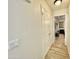 Clean hallway with wood-look tile, white walls, and double doors leading to the bedroom at 2735 E Harwell Rd, Gilbert, AZ 85234