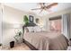 Cozy bedroom with a comfortable bed, ceiling fan, and ample natural light from the window and a glass side table at 288 E Baylor Ln, Gilbert, AZ 85296