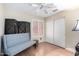 Bright bedroom featuring a light blue bench, privacy screen, closet, ceiling fan, and wood-look flooring at 288 E Baylor Ln, Gilbert, AZ 85296