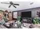 Comfortable living room featuring a ceiling fan, entertainment center with fireplace, stylish decor, and wood-look flooring at 288 E Baylor Ln, Gilbert, AZ 85296