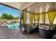 Inviting covered patio with wicker furniture, fire pit, and serene views of the sparkling pool at 288 E Baylor Ln, Gilbert, AZ 85296