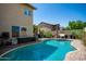 Backyard pool features a curved design, brick coping, and plenty of room for relaxation at 288 E Baylor Ln, Gilbert, AZ 85296