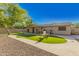 Picture-perfect backyard with lush artificial grass, stone features, and an inviting covered patio at 3 S 130Th Pl, Chandler, AZ 85225