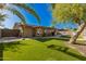 A serene backyard featuring a well-manicured lawn, shaded patio and sport court for outdoor enjoyment at 3 S 130Th Pl, Chandler, AZ 85225