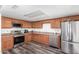 Well-lit kitchen with stainless steel appliances, wood cabinets, and laminate flooring at 3 S 130Th Pl, Chandler, AZ 85225
