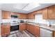Functional kitchen featuring stainless appliances, wood cabinets, laminate counters, and skylight at 3 S 130Th Pl, Chandler, AZ 85225