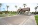 Community entrance with stone gate house, lush landscaping, and a beautifully paved brick street at 3306 E Jaeger Cir, Mesa, AZ 85213
