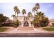 Elegant two-story home featuring a gated entrance, meticulously landscaped yard, and tall palm trees at 3306 E Jaeger Cir, Mesa, AZ 85213