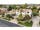 Aerial view showcases a two-story home with a fountain, iron gate, palm trees, and lush landscaping at 3306 E Jaeger Cir, Mesa, AZ 85213