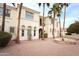 Elegant two-story home showcasing a brick courtyard, fountain, and lush palm tree landscaping at 3306 E Jaeger Cir, Mesa, AZ 85213