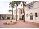 Elegant two-story home showcasing a brick courtyard, fountain, and lush palm tree landscaping at 3306 E Jaeger Cir, Mesa, AZ 85213