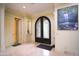 Elegant foyer featuring a decorative iron door, travertine floors, and adjacent closet at 3306 E Jaeger Cir, Mesa, AZ 85213