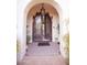 Ornate iron front doors with decorative trim are seen from an arched entry way at 3306 E Jaeger Cir, Mesa, AZ 85213