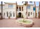 Grand two-story home featuring an ornate fountain and a landscaped brick courtyard with palm trees at 3306 E Jaeger Cir, Mesa, AZ 85213