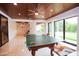 Spacious game room with a ping pong table, wood ceiling, and large sliding glass doors for outdoor access at 3306 E Jaeger Cir, Mesa, AZ 85213