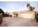 Exterior shot of a three car garage with neutral colors and desert landscaping at 3306 E Jaeger Cir, Mesa, AZ 85213
