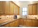 Traditional kitchen featuring light wood cabinetry, granite countertops, and mosaic tile backsplash at 3306 E Jaeger Cir, Mesa, AZ 85213
