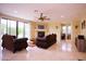Spacious living room features a fireplace, ceiling fan, tile floors, and backyard view at 3306 E Jaeger Cir, Mesa, AZ 85213