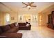 Open-concept living room with a brown sectional sofa and custom built-ins with great natural light at 3306 E Jaeger Cir, Mesa, AZ 85213
