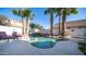 Backyard featuring a custom pool with a rock waterfall, surrounded by lush landscaping and mature palm trees at 3411 S Vine St, Chandler, AZ 85248