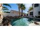 Inviting backyard pool features a rock waterfall, lush palms, and sparkling water perfect for relaxation and entertainment at 3411 S Vine St, Chandler, AZ 85248