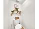 Half bath features wood shelving with greenery above the toilet at 3912 E Rockwood Dr, Phoenix, AZ 85050