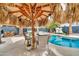 Charming backyard patio area with a tiki-style umbrella, perfect for outdoor dining and entertaining by the pool at 3912 E Rockwood Dr, Phoenix, AZ 85050