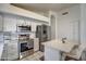 Bright kitchen features stainless steel appliances, a breakfast bar with white marble countertop, and white cabinetry at 4350 E Abraham Ln, Phoenix, AZ 85050