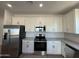 Contemporary kitchen with stainless steel appliances, white cabinets, and stone countertops at 4439 S 95Th Dr, Tolleson, AZ 85353