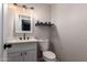 Neat half bath featuring modern vanity, toilet, and decorative lighting fixtures at 4839 W Juniper Ave, Glendale, AZ 85306