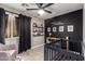 This charming Bedroom features a ceiling fan, a crib, and wall art at 4839 W Juniper Ave, Glendale, AZ 85306
