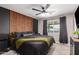 Serene main bedroom featuring a dark accent wall, wood slat detail, and ceiling fan at 4839 W Juniper Ave, Glendale, AZ 85306