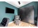 Stylish home office with built-in cabinets, accent chair, and a large-screen television at 4839 W Juniper Ave, Glendale, AZ 85306