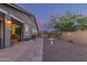 The home's backyard features beautiful hardscaping, landscaping and lighting, and wrought iron fencing at 4876 N 207Th Ln, Buckeye, AZ 85396