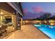 Backyard view of the pool and spa area, covered patio with an outdoor seating area, and desert landscaping at 4876 N 207Th Ln, Buckeye, AZ 85396