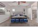 A comfortable bedroom with an upholstered headboard, blue ottomans, and attached bathroom at 4876 N 207Th Ln, Buckeye, AZ 85396