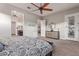 Spacious bedroom features a ceiling fan, ensuite bathroom, and stylish modern furniture at 4876 N 207Th Ln, Buckeye, AZ 85396