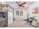 Bright bedroom featuring built-in cabinets, gray accent chair, and a ceiling fan at 4876 N 207Th Ln, Buckeye, AZ 85396