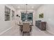 The dining room boasts a stylish chandelier, neutral décor, and a sliding door to the patio at 4876 N 207Th Ln, Buckeye, AZ 85396