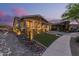 Inviting home exterior at twilight, showcasing desert landscaping, brick accents, and ample driveway space at 4876 N 207Th Ln, Buckeye, AZ 85396