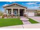Charming single-story home with a welcoming front porch and low-maintenance desert landscaping at 4876 N 207Th Ln, Buckeye, AZ 85396