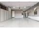 Spacious garage with epoxy floors, recessed lighting, garage door, shelving, and lots of cabinet space at 4876 N 207Th Ln, Buckeye, AZ 85396