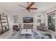 Bright living room featuring a ceiling fan, a cozy rug, and stylish modern furniture at 4876 N 207Th Ln, Buckeye, AZ 85396