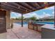 Covered outdoor kitchen with modern appliances, adjacent to a sparkling pool with a swim-up bar at 4876 N 207Th Ln, Buckeye, AZ 85396