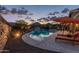 Relaxing backyard retreat featuring a sparkling pool, desert landscaping, and comfortable lounge chairs at 4876 N 207Th Ln, Buckeye, AZ 85396