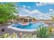 Beautiful backyard oasis with a private pool, spa, bar, and covered seating area at 4876 N 207Th Ln, Buckeye, AZ 85396