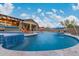 Lush backyard pool boasts integrated spa, a swim-up bar beneath a pergola, and desert landscaping at 4876 N 207Th Ln, Buckeye, AZ 85396