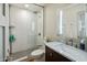 Bathroom featuring textured white tile in the shower, a glass shower door, and a marble vanity at 5104 N 32Nd St # 105, Phoenix, AZ 85018